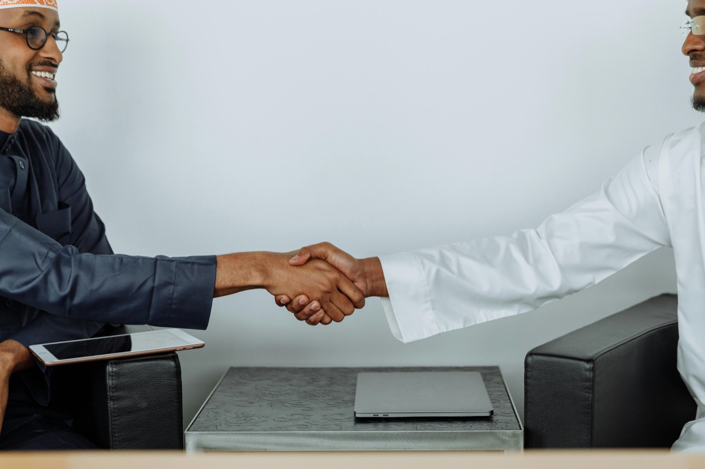 Two professionals shaking hands in a business setting.